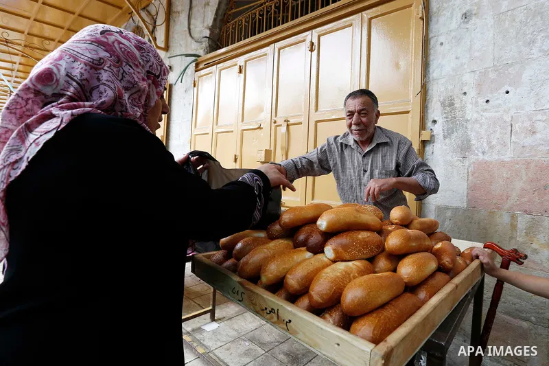 A Palestinian vendor sells bread at a market during the holy fasting month of Ramadan in the West Bank city of Hebron, May 30, 2018. Ramadan is sacred to Muslims because it is during that month that tradition says the Ko...