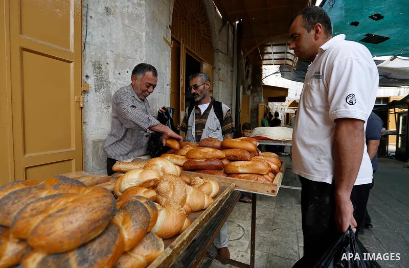 A Palestinian vendor sells bread at a market during the holy fasting month of Ramadan in the West Bank city of Hebron, May 30, 2018. Ramadan is sacred to Muslims because it is during that month that tradition says the Ko...