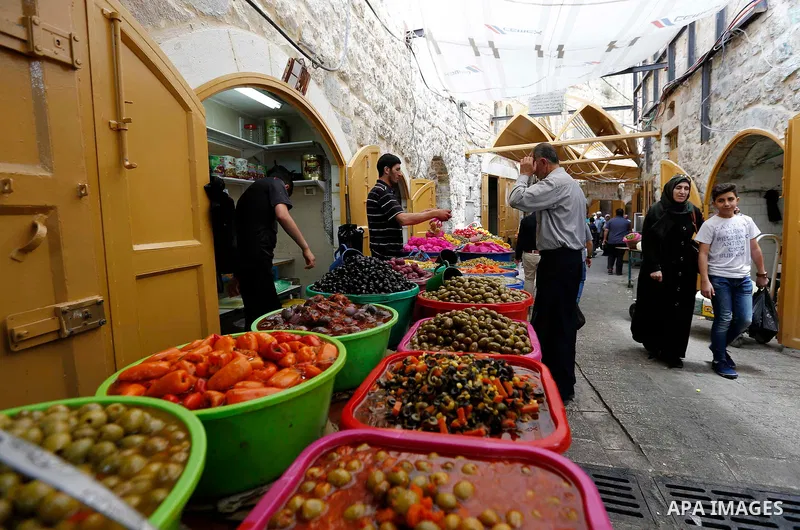 A Palestinian vendor sells pickles at a market during the holy fasting month of Ramadan in the West Bank city of Hebron, May 30, 2018. Ramadan is sacred to Muslims because it is during that month that tradition says the...