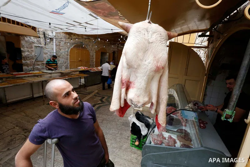 A Palestinian vendor sells meats at a market during the holy fasting month of Ramadan in the West Bank city of Hebron, May 30, 2018. Ramadan is sacred to Muslims because it is during that month that tradition says the Ko...