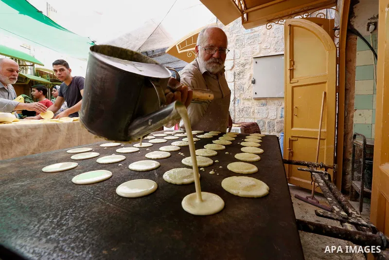 A Palestinian vendor prepares "Qatayef", traditional pancakes that are popular at a market during the holy month of Ramadan, in the West Bank city of Hebron, May 30, 2018. Ramadan is sacred to Muslims because it is durin...