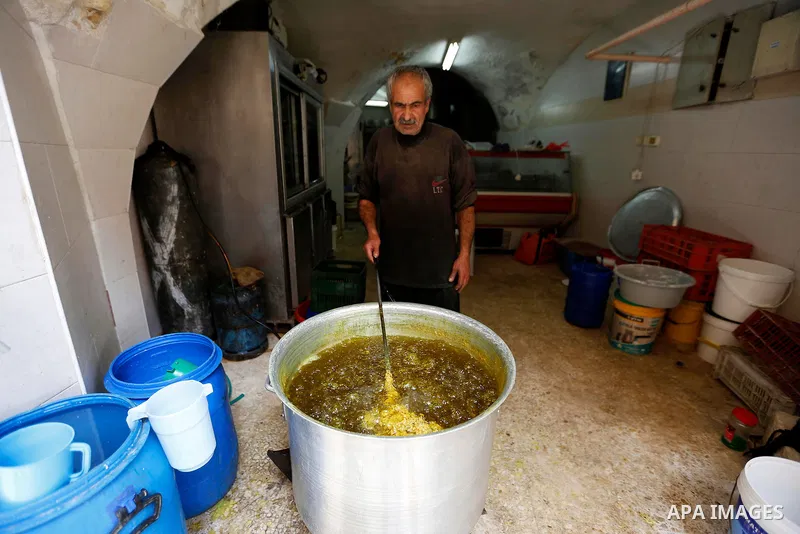 A Palestinian vendor prepares sweets at a market during the holy fasting month of Ramadan in the West Bank city of Hebron, May 30, 2018. Ramadan is sacred to Muslims because it is during that month that tradition says th...