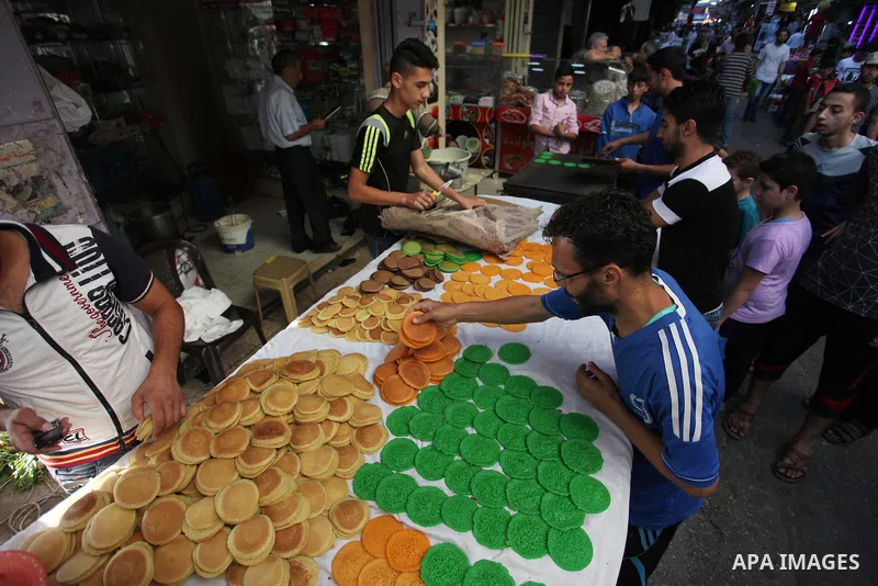 A Palestinian vendor prepares "Qatayef", traditional pancakes that are popular at a market during the holy month of Ramadan in Gaza city of June 1, 2018. Ramadan is sacred to Muslims because it is during that month that...