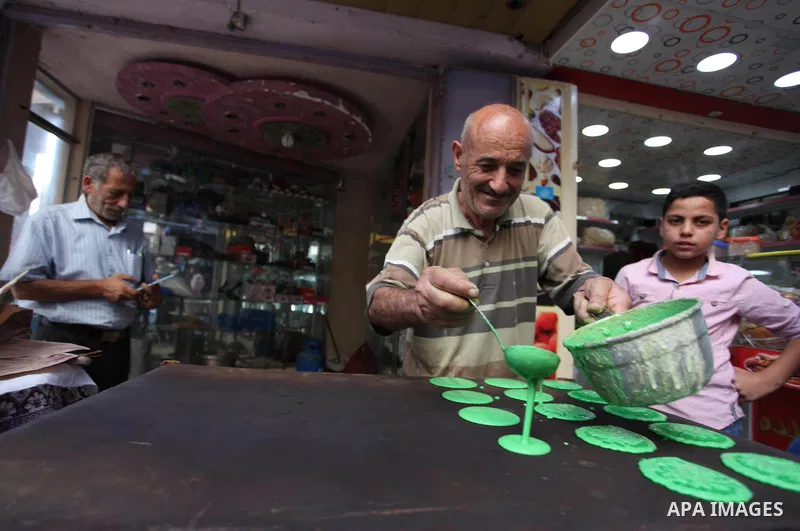 A Palestinian vendor prepares "Qatayef", traditional pancakes that are popular at a market during the holy month of Ramadan in Gaza city of June 1, 2018. Ramadan is sacred to Muslims because it is during that month that...