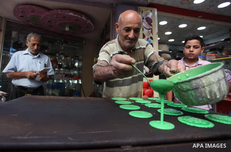 A Palestinian vendor prepares "Qatayef", traditional pancakes that are popular at a market during the holy month of Ramadan in Gaza city of June 1, 2018. Ramadan is sacred to Muslims because it is during that month that...