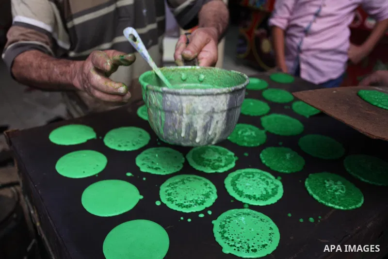 A Palestinian vendor prepares "Qatayef", traditional pancakes that are popular at a market during the holy month of Ramadan in Gaza city of June 1, 2018. Ramadan is sacred to Muslims because it is during that month that...