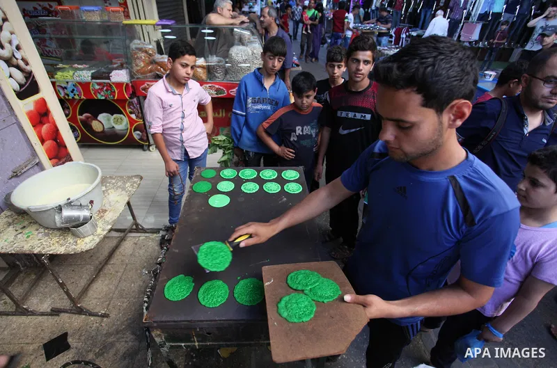 A Palestinian vendor prepares "Qatayef", traditional pancakes that are popular at a market during the holy month of Ramadan in Gaza city of June 1, 2018. Ramadan is sacred to Muslims because it is during that month that...