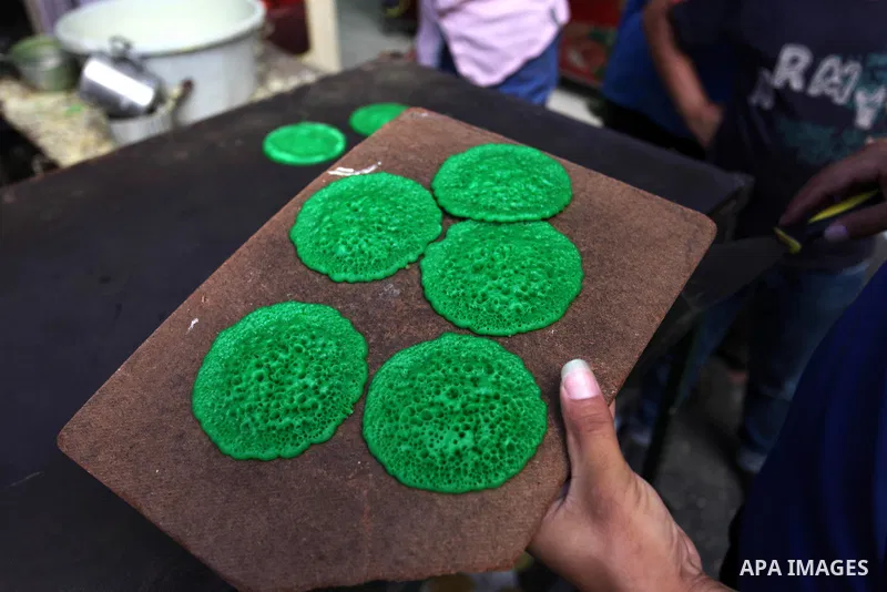A Palestinian vendor prepares "Qatayef", traditional pancakes that are popular at a market during the holy month of Ramadan in Gaza city of June 1, 2018. Ramadan is sacred to Muslims because it is during that month that...