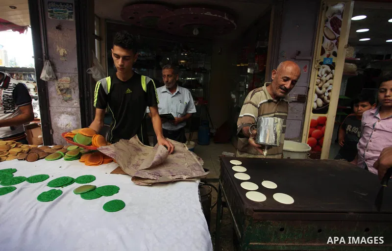A Palestinian vendor prepares "Qatayef", traditional pancakes that are popular at a market during the holy month of Ramadan in Gaza city of June 1, 2018. Ramadan is sacred to Muslims because it is during that month that...