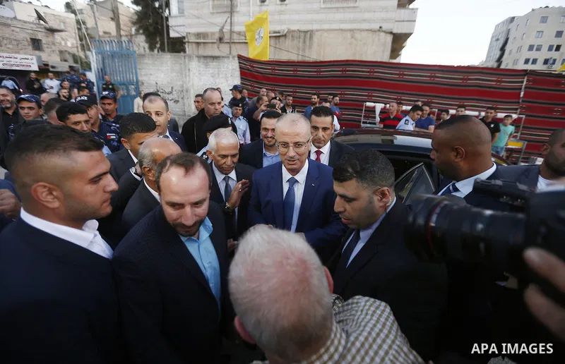 Palestinian Prime Minister, Rami Hamdallah, attends a charity breakfast to the families of martyrs and prisoners organized by the Fatah movement, during the holy month of Ramadan in the West Bank city of Hebron on June 1...