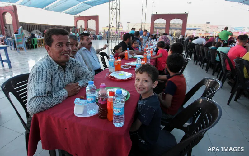 Palestinian families of martyrs and prisoners attends a breakfast during the holy fasting month of Ramadan in Gaza city on June 1, 2018. Ramadan is sacred to Muslims because it is during that month that tradition says th...