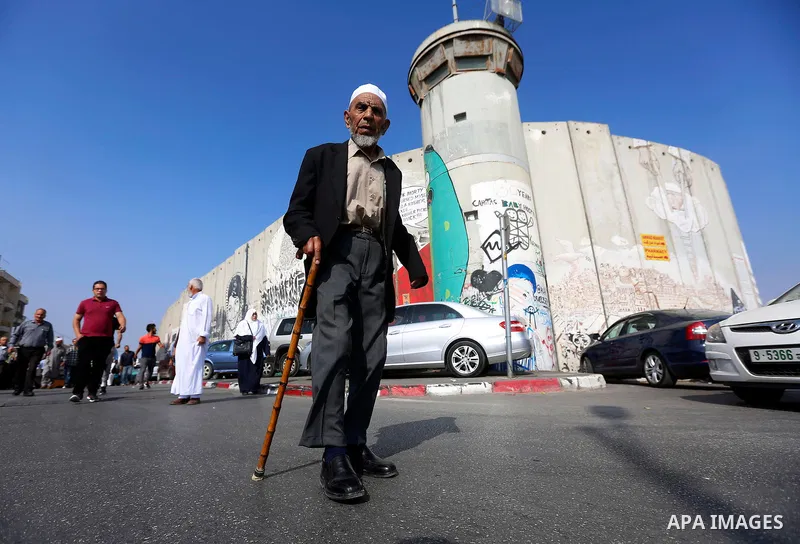 Palestinians make their way through an Israeli checkpoint along Israel's controversial separation barrier to attend the third Friday prayer of the holy fasting month of Ramadan in Jerusalem's Al-Aqsa mosque, in Bethlehem...