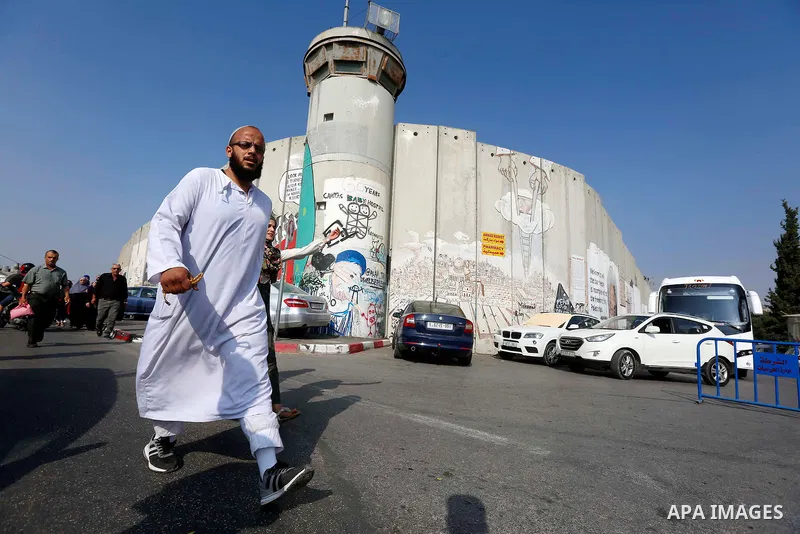 Palestinians make their way through an Israeli checkpoint along Israel's controversial separation barrier to attend the third Friday prayer of the holy fasting month of Ramadan in Jerusalem's Al-Aqsa mosque, in Bethlehem...