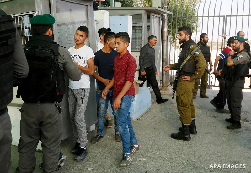 Palestinians make their way through an Israeli checkpoint along Israel's controversial separation barrier to attend the third Friday prayer of the holy fasting month of Ramadan in Jerusalem's Al-Aqsa mosque, in Bethlehem...