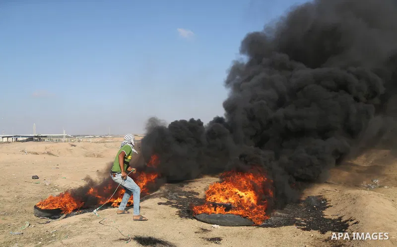 Palestinian protesters gather during clashes with Israeli security froces in a tent city protest where Palestinians demand the right to return to their homeland and against U.S. embassy move to Jerusalem at the Israel-Ga...
