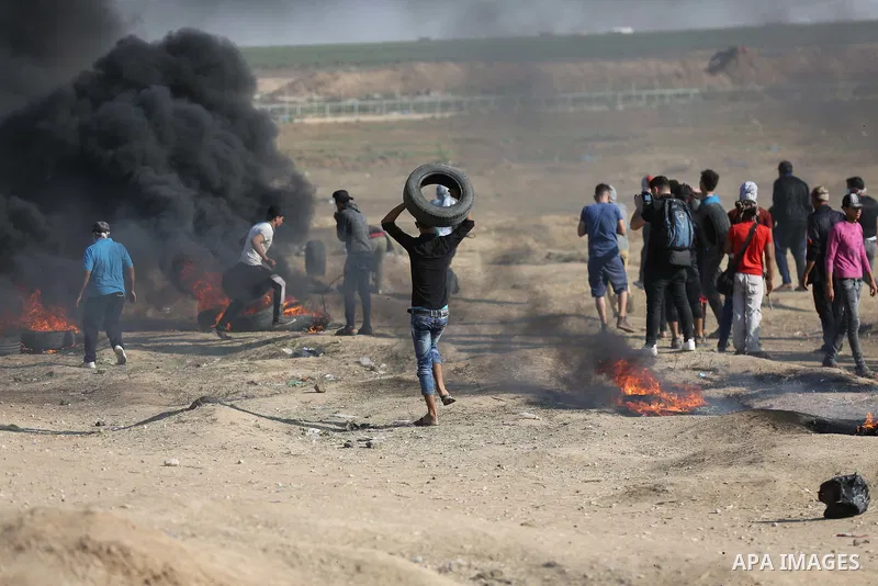 Palestinian protesters gather during clashes with Israeli security froces in a tent city protest where Palestinians demand the right to return to their homeland and against U.S. embassy move to Jerusalem at the Israel-Ga...