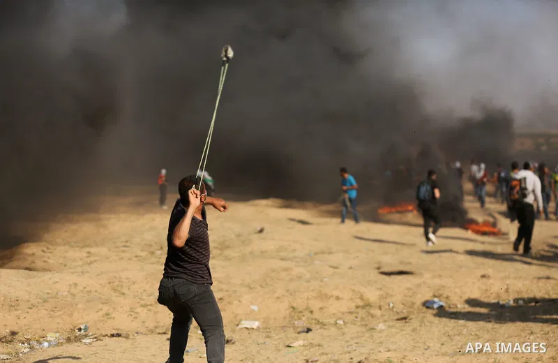 Palestinian protesters gather during clashes with Israeli security froces in a tent city protest where Palestinians demand the right to return to their homeland and against U.S. embassy move to Jerusalem at the Israel-Ga...