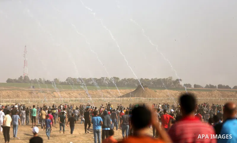 Palestinian protesters gather during clashes with Israeli security froces in a tent city protest where Palestinians demand the right to return to their homeland and against U.S. embassy move to Jerusalem at the Israel-Ga...