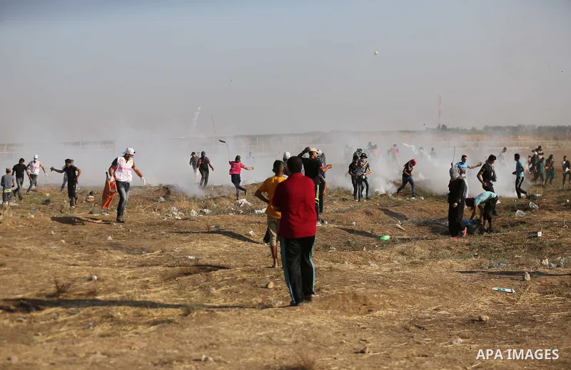 Palestinian protesters gather during clashes with Israeli security froces in a tent city protest where Palestinians demand the right to return to their homeland and against U.S. embassy move to Jerusalem at the Israel-Ga...