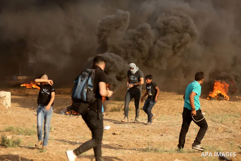 Palestinian protesters gather during clashes with Israeli security froces in a tent city protest where Palestinians demand the right to return to their homeland and against U.S. embassy move to Jerusalem at the Israel-Ga...