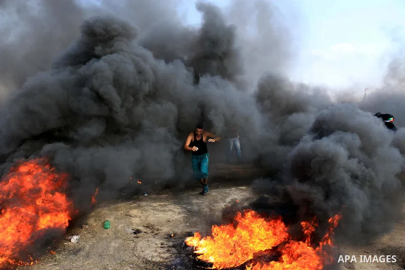 Palestinian protesters gather during clashes with Israeli security froces in a tent city protest where Palestinians demand the right to return to their homeland and against U.S. embassy move to Jerusalem at Israel-Gaza b...