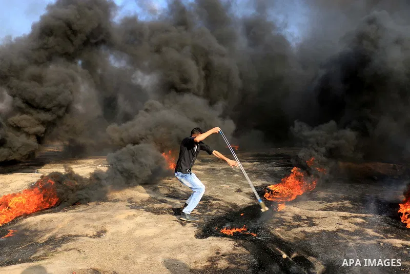 Palestinian protesters gather during clashes with Israeli security froces in a tent city protest where Palestinians demand the right to return to their homeland and against U.S. embassy move to Jerusalem at Israel-Gaza b...