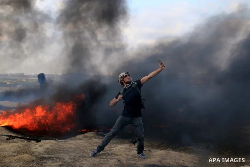 Palestinian protesters gather during clashes with Israeli security froces in a tent city protest where Palestinians demand the right to return to their homeland and against U.S. embassy move to Jerusalem at Israel-Gaza b...