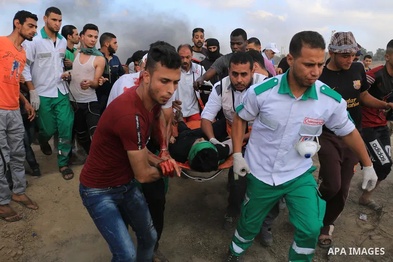 Palestinian protesters gather during clashes with Israeli security froces in a tent city protest where Palestinians demand the right to return to their homeland and against U.S. embassy move to Jerusalem at Israel-Gaza b...