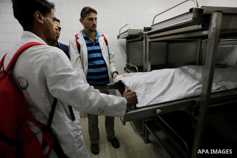 Colleagues of Palestinian medic Razan al-Najar, 21, who was killed during a protest at the Israel-Gaza border, mourn over the body at a hospital morgue in Khan Younis in the southern Gaza Strip, on June 1, 2018. Photo by...