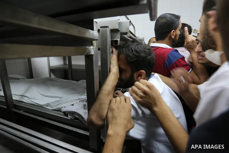 Colleagues of Palestinian medic Razan al-Najar, 21, who was killed during a protest at the Israel-Gaza border, mourn over her body at a hospital morgue in Khan Younis in the southern Gaza Strip, on June 1, 2018. Photo by...