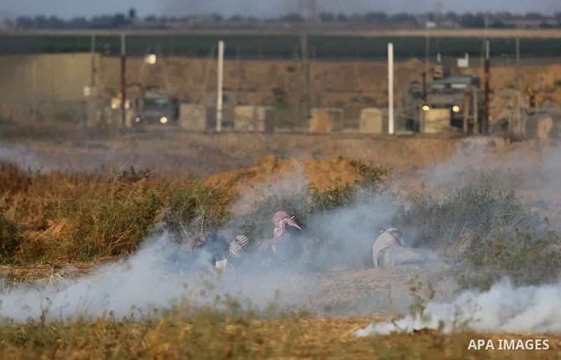 Palestinian protesters gather during clashes with Israeli security froces in a tent city protest where Palestinians demand the right to return to their homeland and against U.S. embassy move to Jerusalem at the Israel-Ga...