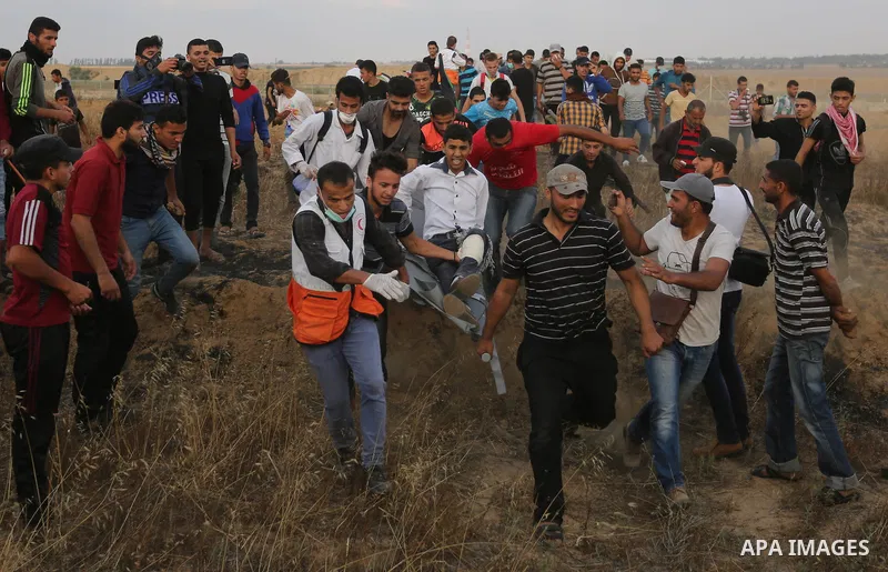 A wounded Palestinian protester is evacuated during clashes with Israeli security froces in a tent city protest where Palestinians demand the right to return to their homeland and against U.S. embassy move to Jerusalem a...