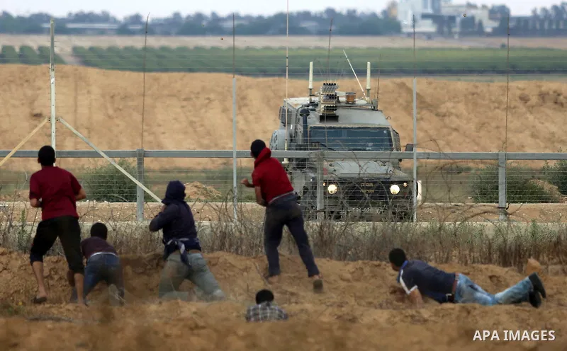 Palestinian protesters gather during clashes with Israeli security froces in a tent city protest where Palestinians demand the right to return to their homeland and against U.S. embassy move to Jerusalem at the Israel-Ga...