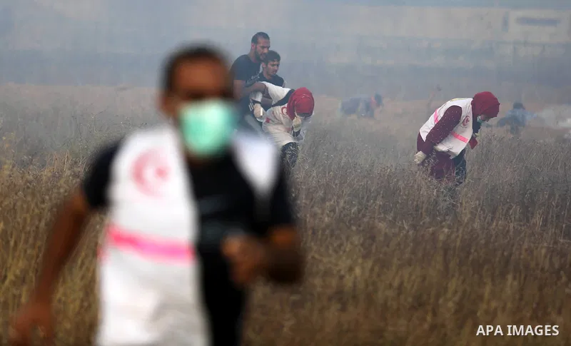 Palestinian protesters run for cover from tear gas canisters fired by Israeli security forces during clashes in a tent city protest where Palestinians demand the right to return to their homeland and against U.S. embassy...