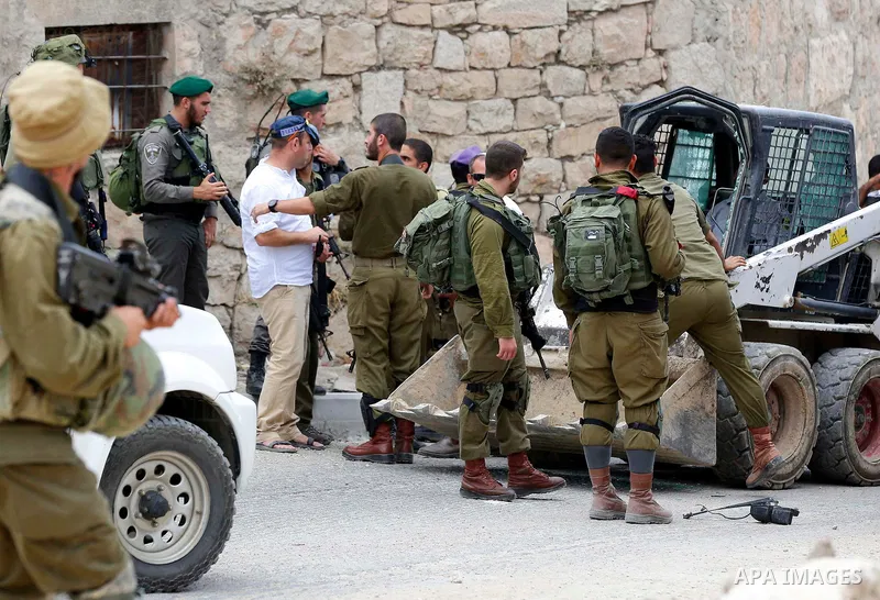 Israeli soldiers gather at the scene of what the Israeli military said was car-ramming attacks by a Palestinian man in the West Bank city of Hebron on June 2, 2018. The Israeli army shot dead Rami Sabarneh, 36, in the Ja...