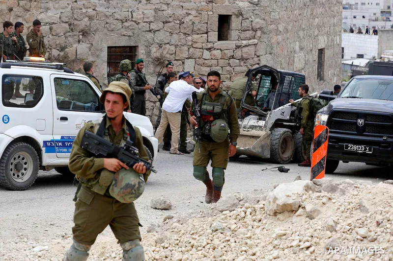 Israeli soldiers gather at the scene of what the Israeli military said was car-ramming attacks by a Palestinian man in the West Bank city of Hebron on June 2, 2018. The Israeli army shot dead Rami Sabarneh, 36, in the Ja...