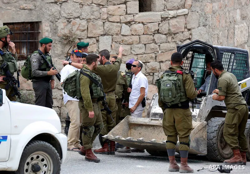 Israeli soldiers gather at the scene of what the Israeli military said was car-ramming attacks by a Palestinian man in the West Bank city of Hebron on June 2, 2018. The Israeli army shot dead Rami Sabarneh, 36, in the Ja...