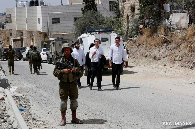 Israeli soldiers gather at the scene of what the Israeli military said was car-ramming attacks by a Palestinian man in the West Bank city of Hebron on June 2, 2018. The Israeli army shot dead Rami Sabarneh, 36, in the Ja...