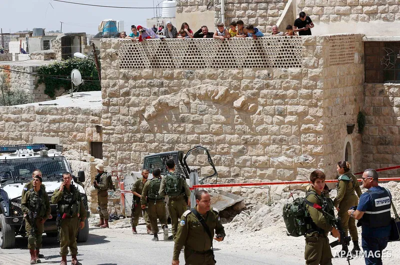 Israeli soldiers gather at the scene of what the Israeli military said was car-ramming attacks by a Palestinian man in the West Bank city of Hebron on June 2, 2018. The Israeli army shot dead Rami Sabarneh, 36, in the Ja...