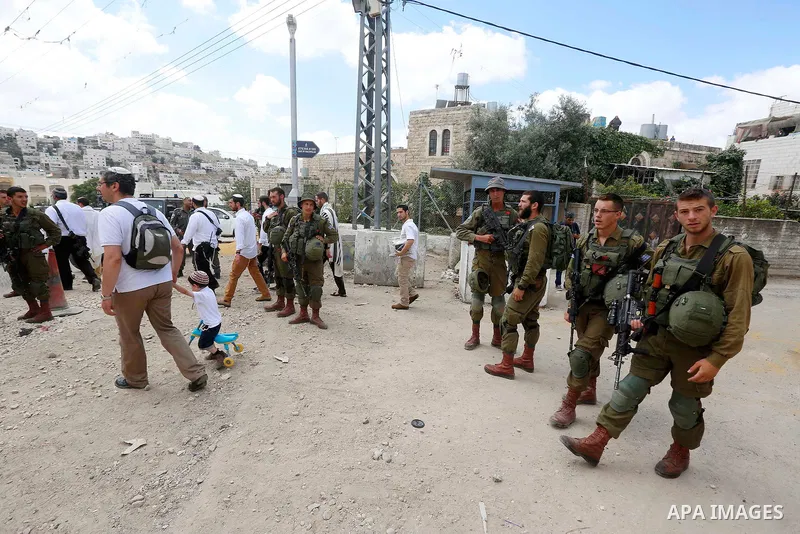Israeli soldiers gather at the scene of what the Israeli military said was car-ramming attacks by a Palestinian man in the West Bank city of Hebron on June 2, 2018. The Israeli army shot dead Rami Sabarneh, 36, in the Ja...