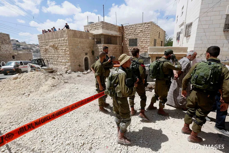 Israeli soldiers gather at the scene of what the Israeli military said was car-ramming attacks by a Palestinian man in the West Bank city of Hebron on June 2, 2018. The Israeli army shot dead Rami Sabarneh, 36, in the Ja...