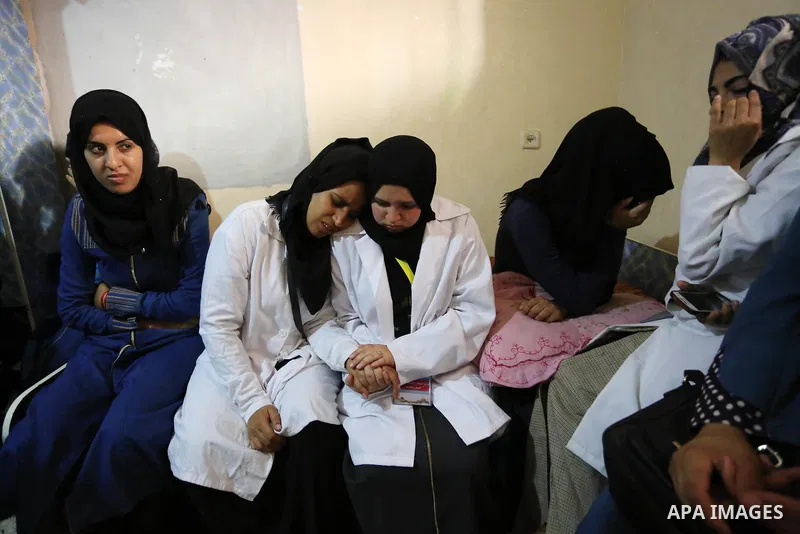 Coworkers of Palestinian nurse Razan Al-Najar, 21, mourn during her funeral after she was shot dead by Israeli soldiers, in Khan Younis in the southern Gaza strip on June 2, 2018. Najar, a volunteer medic, was shot by Is...