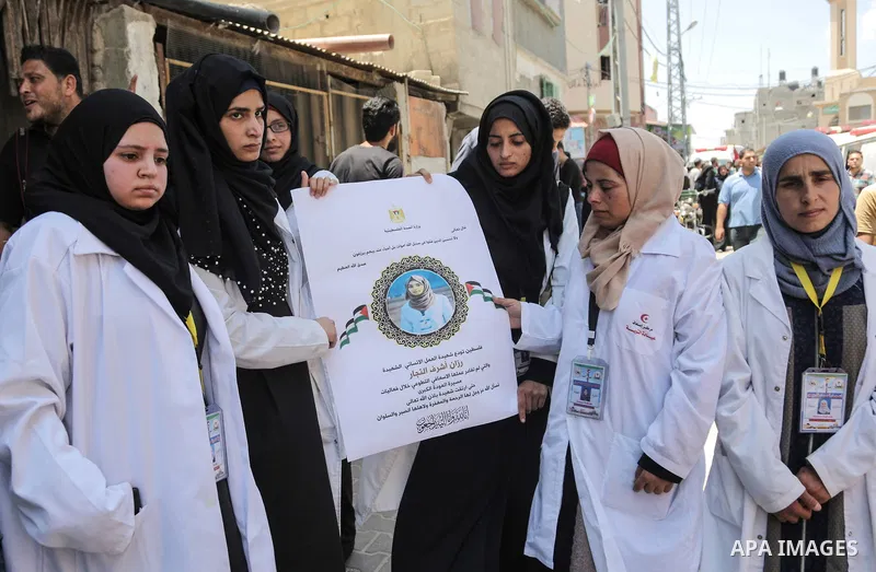 Coworkers of Palestinian nurse Razan Al-Najar, 21, mourn during her funeral after she was shot dead by Israeli soldiers, in Khan Younis in the southern Gaza strip on June 2, 2018. Najar, a volunteer medic, was shot by Is...