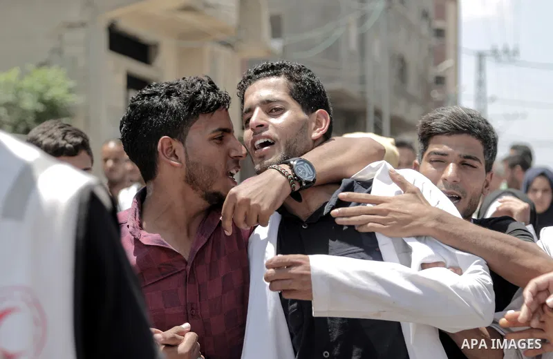 Coworkers of Palestinian nurse Razan Al-Najar, 21, mourn during her funeral after she was shot dead by Israeli soldiers, in Khan Younis in the southern Gaza strip on June 2, 2018. Najar, a volunteer medic, was shot by Is...
