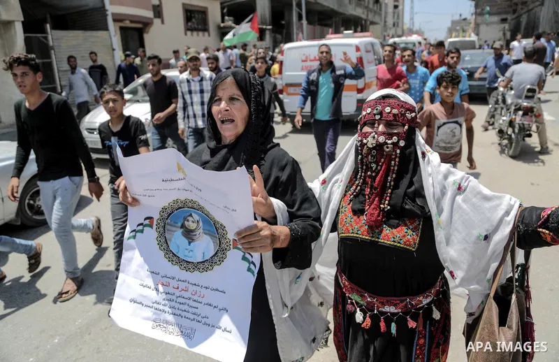 Coworkers of Palestinian nurse Razan Al-Najar, 21, mourn during her funeral after she was shot dead by Israeli soldiers, in Khan Younis in the southern Gaza strip on June 2, 2018. Najar, a volunteer medic, was shot by Is...