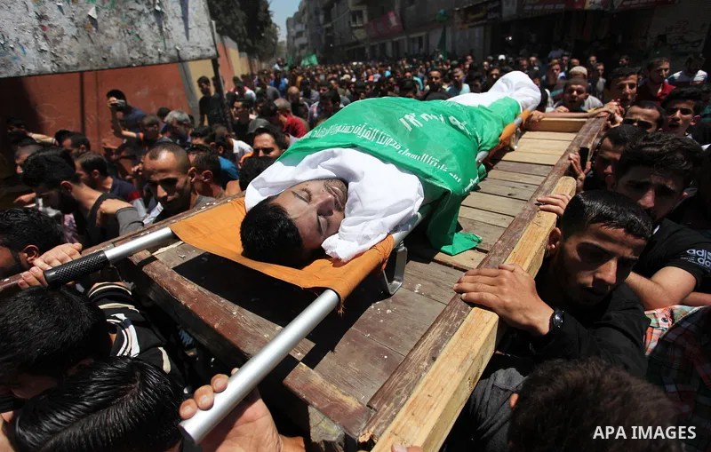 Palestinian mourners carry the body of Mohammed Hamada, 30, who died of his wounds endured during clashes with Israeli troops in a tent city protest where Palestinians demand the right to return to their homeland at the...