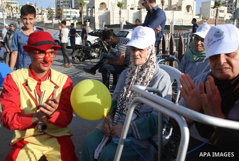 Palestinian elderlies attend the opening ceremony of a mural for their rights at Gaza seaport, on June 4, 2018. Photo by Mahmoud Ajour