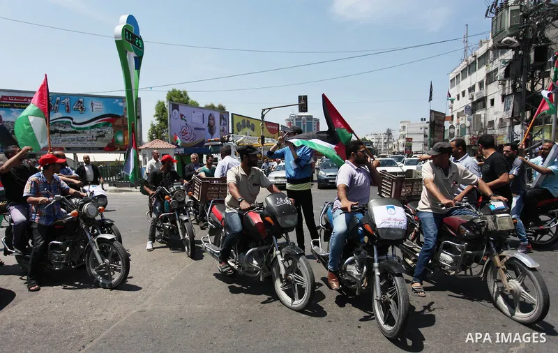 Palestinians ride motorcycles and carry the Palestinian flag during a demonstration organized by the National Authority for Return and Breaking the Siege in Gaza City, June 5, 2018. Photo by Mahmoud Ajour