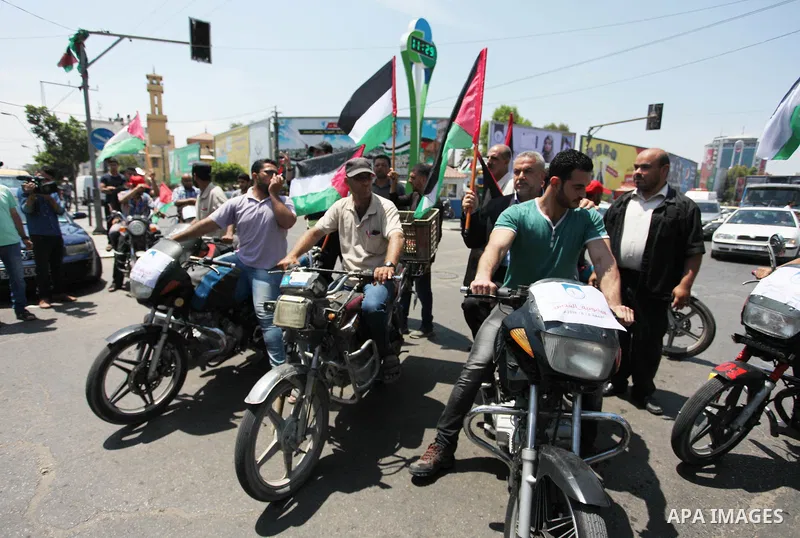 Palestinians ride motorcycles and carry the Palestinian flag during a demonstration organized by the National Authority for Return and Breaking the Siege in Gaza City, June 5, 2018. Photo by Mahmoud Ajour