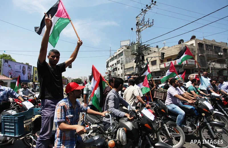 Palestinians ride motorcycles and carry the Palestinian flag during a demonstration organized by the National Authority for Return and Breaking the Siege in Gaza City, June 5, 2018. Photo by Mahmoud Ajour